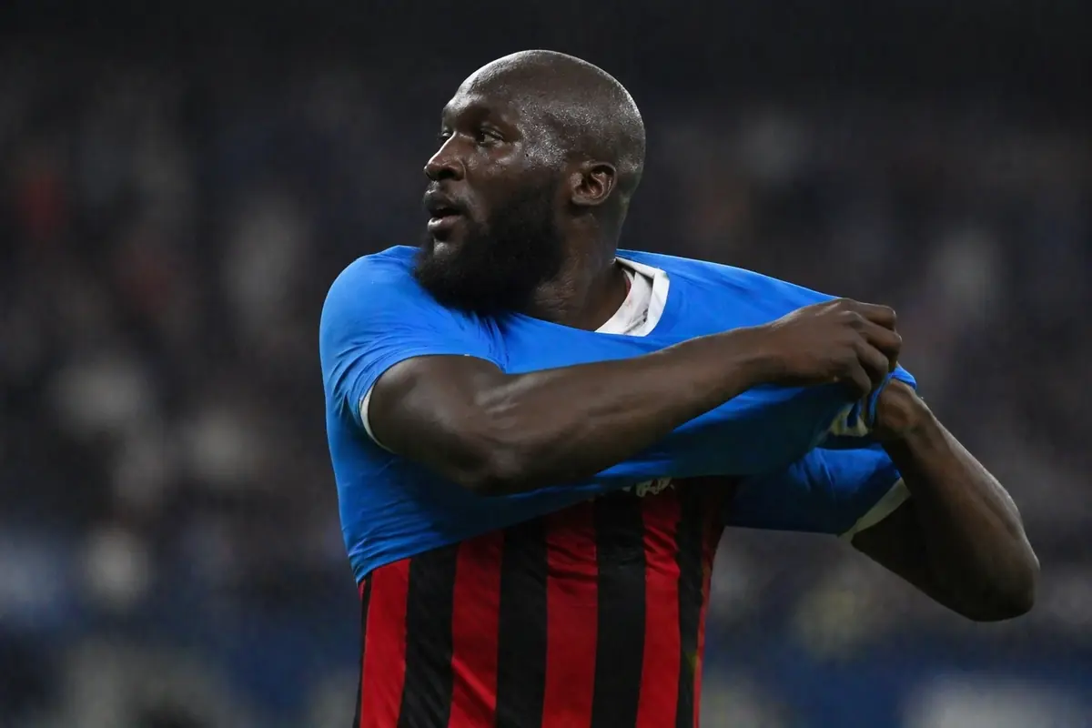 Lukaku si toglie la maglia del Napoli e sotto si intravede quella del Milan, immagine creata con intelligenza artificiale